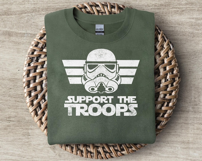 May include: A green t-shirt with a white graphic of a Star Wars Stormtrooper helmet and the text "SUPPORT THE TROOPS".