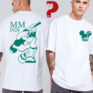 May include: White t-shirts with green graphics. One shirt features a green Mickey Mouse design with the text "MM 1928" on the back. The other shirt has a green Mickey Mouse head design on the pocket.