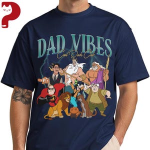 Peut inclure: T-shirt bleu marine avec l'inscription "DAD VIBES Cool Dads Club" et un dessin anim&eacute; de personnages anim&eacute;s. Le dessin anim&eacute; comprend des personnages de diff&eacute;rents films d'animation. Le t-shirt est &agrave; col rond et &agrave; manches courtes.