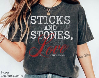 May include: A dark gray t-shirt with a distressed white graphic that reads "Sticks and Stones, Love - Captain Jack".