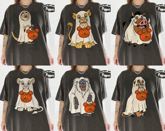 May include: A charcoal gray t-shirt featuring a graphic print of six different cartoon characters dressed in white ghost costumes for Halloween. Each character holds an orange pumpkin-shaped candy bucket with mouse ears. The shirt has a Comfort Colors Pepper label.