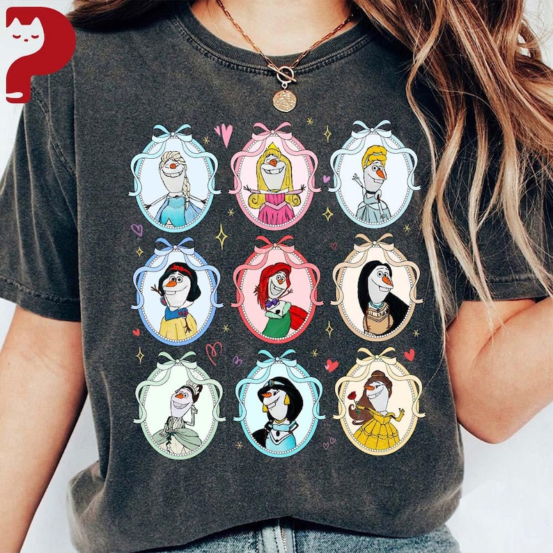 May include: Dark gray t-shirt featuring a grid of cartoon characters in oval frames with bows. The characters include a snowman, princesses, and other figures. The frames are in various pastel colors, with hearts and stars scattered around the design.