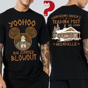 May include: Black t-shirt featuring a cartoon image of a character with the text "Yoohoo Big Summer Blowout". The back of the shirt displays a cabin with the text "Wandering Oaken's Trading Post and Sauna" and "Arendelle".