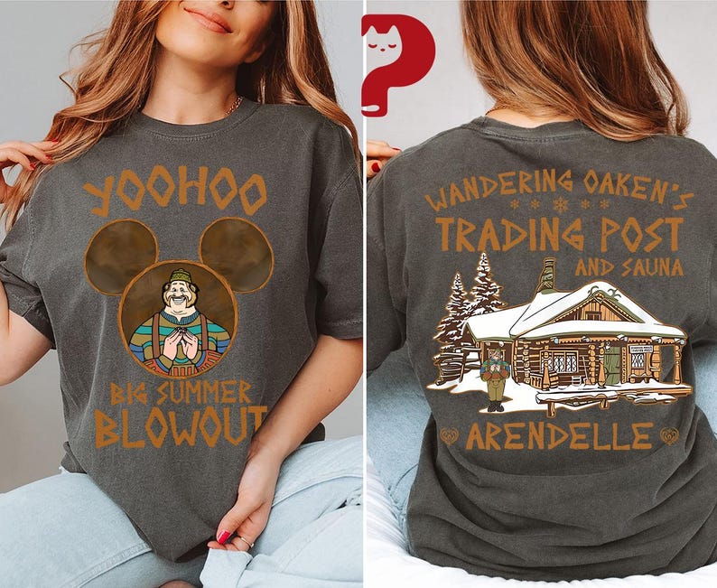 May include: Dark gray t-shirt featuring a cartoon image of a character with the text "Yoohoo Big Summer Blowout" on the front. The back of the shirt displays "Wandering Oaken's Trading Post and Sauna Arendelle" with a cabin graphic. The shirt is a casual wear item.