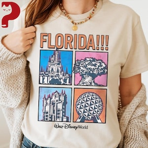 May include: Beige t-shirt with the word "FLORIDA!!!" in orange block letters. Below the text are four squares with illustrations of a castle, a tree, a building, and a geometric sphere. The words "Walt Disney World" are printed below the squares.