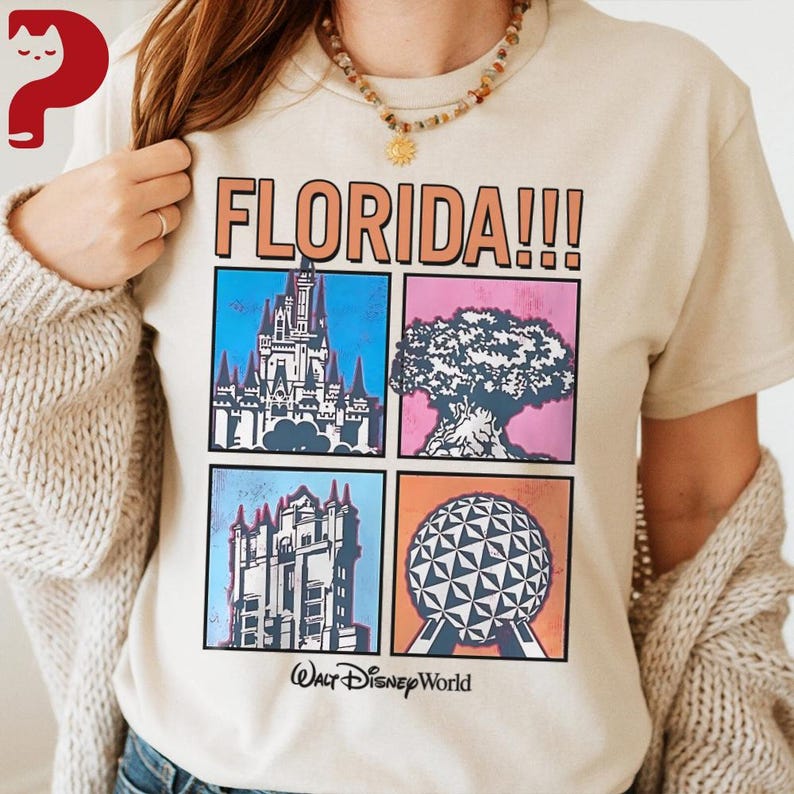 May include: Beige t-shirt with the word "FLORIDA!!!" in orange block letters. Below the text are four squares with illustrations of a castle, a tree, a building, and a geometric sphere. The words "Walt Disney World" are printed below the squares.