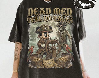 May include: A charcoal gray t-shirt featuring a graphic print with the text "DEAD MEN TELL NO TALES". The design depicts a cartoon mouse and a skeleton dressed as pirates at a ship's wheel, with treasure chests, parrots, and a map.