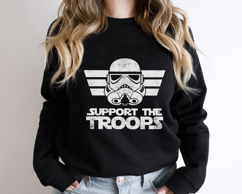 May include: Black sweatshirt with a white graphic of a Star Wars Stormtrooper helmet with the text "SUPPORT THE TROOPS" underneath.