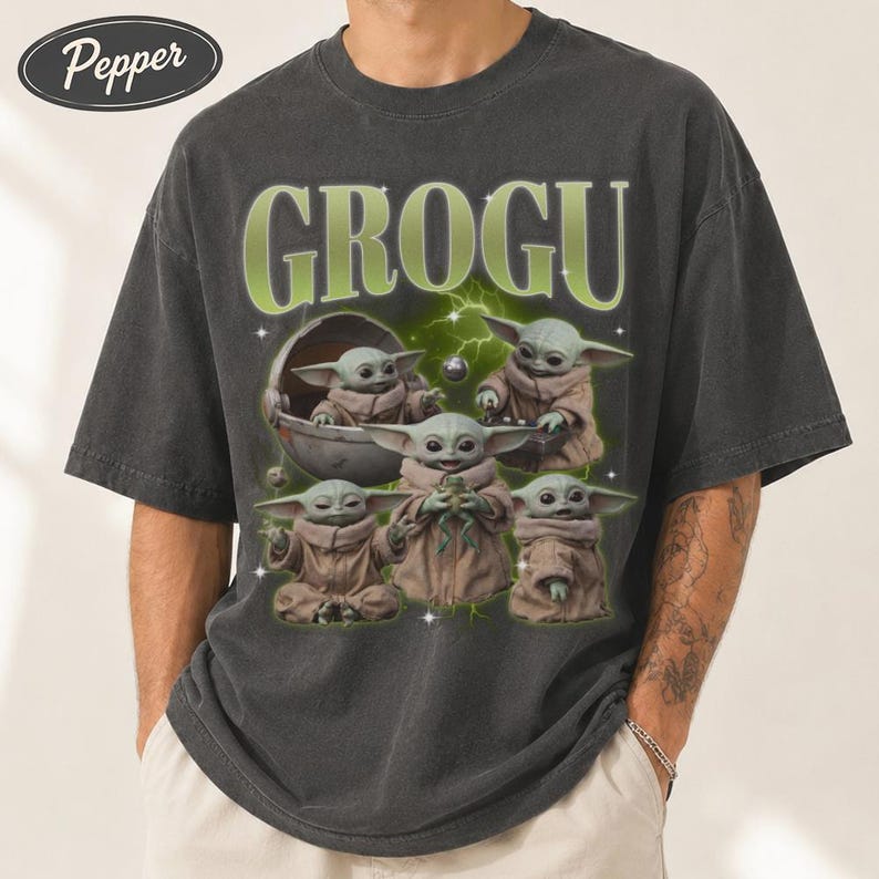 May include: Dark gray t-shirt featuring the word "GROGU" in green, with a graphic of Grogu from The Mandalorian. The graphic shows Grogu in various poses, with a green and white lightning bolt design in the background.