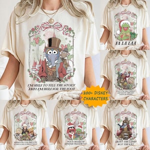 May include: Cream-colored t-shirts with various Disney-themed Christmas designs. One shirt features Gonzo, another Kermit the Frog, and others with different characters. Text includes "I'm here to tell the story", "Fa La Laa", and "200+ Disney Characters".