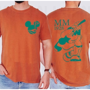 May include: A white ceramic mug with a black handle and the text "But First, Coffee" in a bold, black font. The mug is set against a blurred background, suggesting a cozy setting.