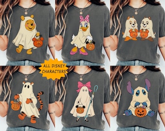 May include: A collection of six charcoal gray t-shirts featuring various cartoon characters dressed in white ghost costumes for Halloween. Each character holds a small orange jack-o'-lantern bucket. A yellow starburst graphic reads ALL DISNEY CHARACTERS.