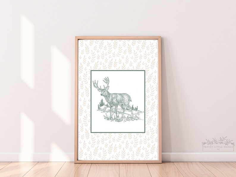 May include: A framed print with a white background and a green line pattern. The print features a line drawing of a deer in a forest setting.