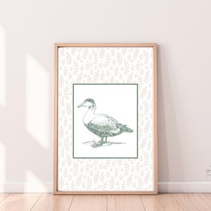 May include: A framed print with a green line drawing of a duck on a white background. The background of the print is a light pink pattern of leaves.