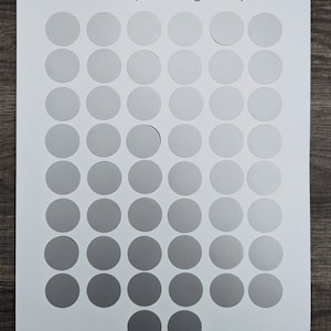 May include: A white card with the text "50 Envelope Challenge Mix-up" printed at the top. The card is divided into a grid of 50 circles, each a different shade of gray, ranging from light to dark.