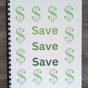 May include: A white notebook with a black spiral binding. The notebook has green dollar signs and the text "Save Save Save" written on it.