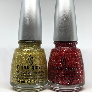 May include: Two bottles of China Glaze nail lacquer. One is gold with glitter, the other is red with glitter. Both have silver caps and the text "China Glaze" is visible. Each bottle contains 14 ml of nail lacquer.
