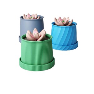 May include: Three succulent planters in green, blue, and grey. Each planter has a matching saucer and a faux succulent with pink and green petals. The planters are made of plastic. The planters are suitable for indoor use.