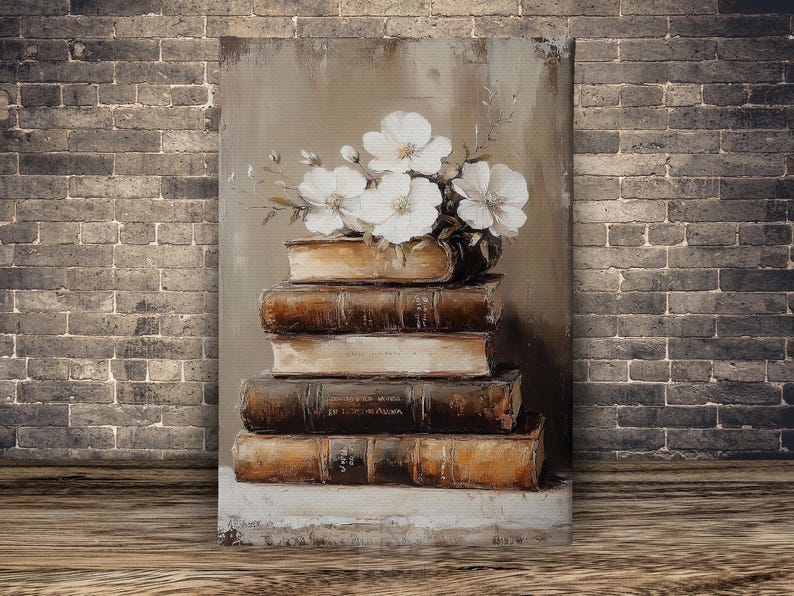 May include: An oil painting depicts a stack of old books with white flowers in a vase on top. The books are brown and beige, with visible text on the spines. The background is a neutral color, and the painting is set against a brick wall.