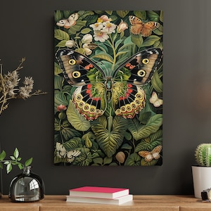 Op de afbeelding: Een grote, kleurrijke vlinder met zwarte, groene, gele en rode vleugels is omringd door groene bladeren en witte bloemen. De vlinder is het middelpunt van de afbeelding, met de bladeren en bloemen die een natuurlijke achtergrond vormen.
