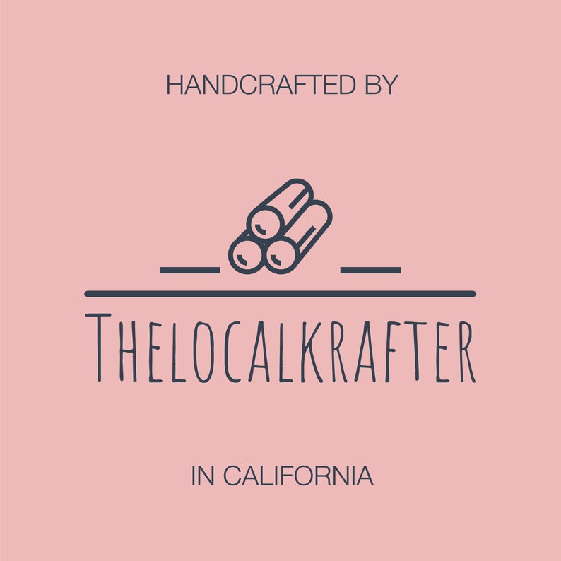 Puede incluir: Un logotipo sobre un fondo rosa. El logotipo presenta el texto "HANDCRAFTED BY" encima de un gr&aacute;fico de tres troncos. Debajo, el texto "THELOCALKRAFTER" y "IN CALIFORNIA". El logotipo es de color azul oscuro.