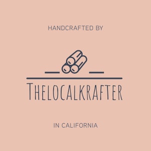 May include: A logo on a peach background features the text "HANDCRAFTED BY" above a graphic of three logs. Below the logs is the text "THELOCALKRAFTER" and "IN CALIFORNIA". The logo is in a dark blue color.