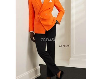 Könnte beinhalten: Ein orangefarbener Doppelreiher-Blazer mit schwarzer Hose, einem weißen Hemd und einer schwarzen Fliege. Der Blazer hat goldene Knöpfe und ein Einstecktuch. Das Outfit wird durch schwarze Loafer vervollständigt. Der Text "TAYLUX" ist sichtbar.