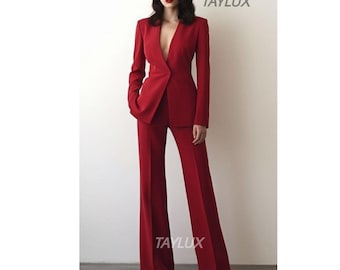May include: A vibrant red suit featuring a tailored blazer with a plunging neckline and wide-leg trousers. The suit is a solid color, with the brand name "TAYLUX" visible in the upper right and lower left corners.
