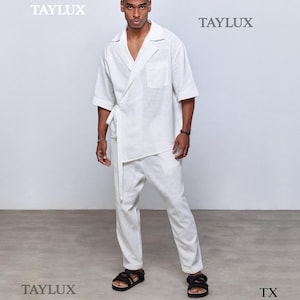 May include: A white linen wrap shirt and matching pants set. The shirt has short sleeves and a tie closure. The pants are straight-legged. The model is wearing black sandals. The brand name "TAYLUX" is visible in the image.