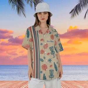May include: A beige button-up shirt with a tropical print featuring palm leaves, disc golf discs, and the text "Your Name".