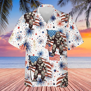 May include: A white short-sleeved button-up shirt with a pattern of a gorilla holding an American flag, fireworks, and stars.