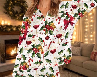 May include: White Christmas-themed pajama set with a festive pattern. The set features red wine glasses, bows, holly, and candy canes. The pajamas have red trim and are button-down.