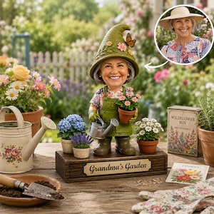 Könnte beinhalten: Eine skurrile Gartenzwergfigur einer lächelnden Frau mit grünem Hut und Schürze, die eine Gießkanne und Topfblumen hält. Die Figur steht auf einem Holzsockel mit der Aufschrift "Grandma's Garden", umgeben von Gartengeräten und Blumen.