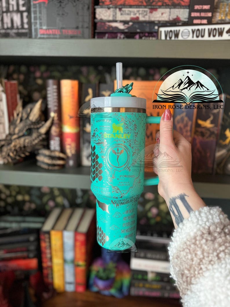 May include: A turquoise stainless steel tumbler with a gold design featuring a dragon, honeycomb pattern, and the text "FOROMIEL" and "WINGED ACE". The tumbler has a lid and a straw.