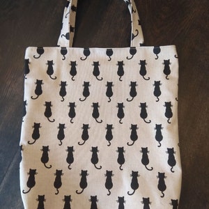 Grote boodschappentas met een stevige bodem en twee verschillende kattenmotieven, dubbellaags voor extra duurzaamheid, en omkeerbaar.