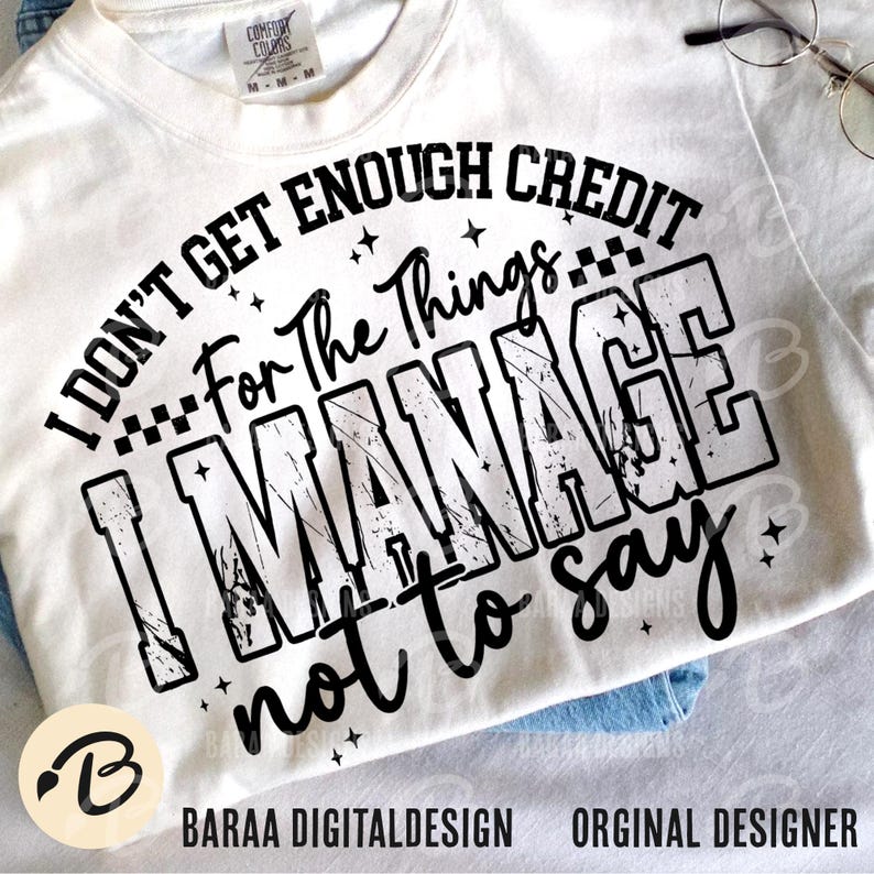 May include: Cream-colored t-shirt with the text "I DON'T GET ENOUGH CREDIT For The Things I MANAGE not to say" in black. The shirt has a distressed, vintage style design. The brand name and designer's name are at the bottom.