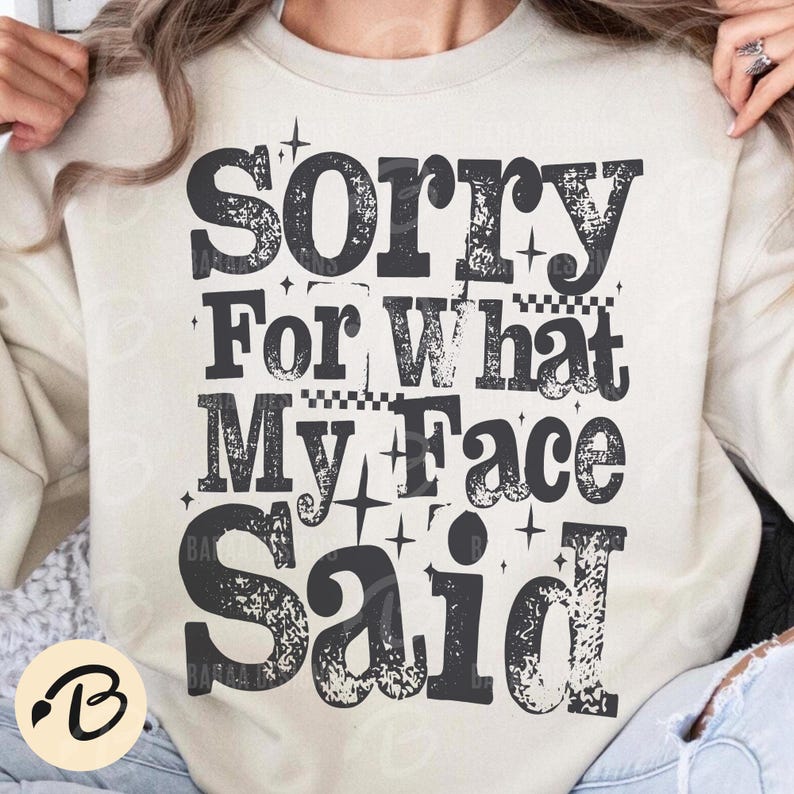 Pu&ograve; includere: Felpa color crema con la scritta "Sorry For What My Face Said" in lettere nere sbiadite. Il design include stelle e un motivo a scacchi, creando un'estetica vintage. Un top casual e confortevole.