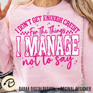 May include: A light pink sweatshirt with the text "I DON'T GET ENOUGH CREDIT For The Things I MANAGE not to say" in white and pink. The sweatshirt has long sleeves and a crew neck. The design includes stars and the words "BARAA DESIGNS".
