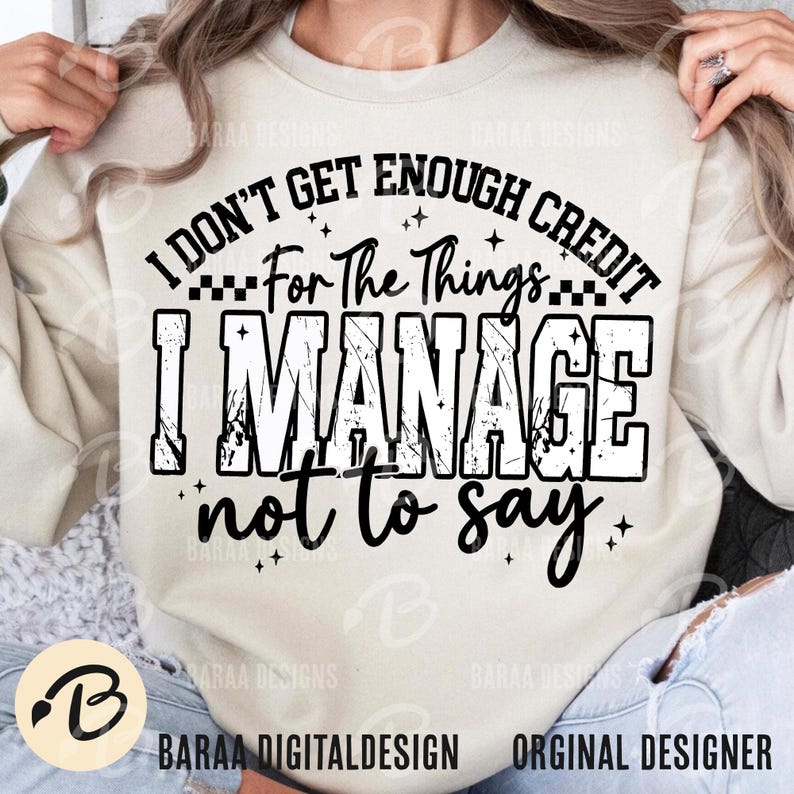 May include: Cream-colored sweatshirt with the text "I DON'T GET ENOUGH CREDIT For The Things I MANAGE not to say" in black. The design includes stars and a checkered pattern. The brand logo is visible at the bottom left.