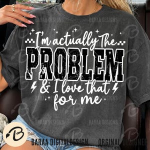 May include: A charcoal grey short-sleeve t-shirt featuring white text that reads I'm actually The PROBLEM & I love that for me. The design includes small star and lightning bolt graphics surrounding the bold, distressed-style lettering.