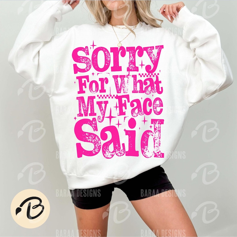 Pu&ograve; includere: Felpa bianca con la scritta "Sorry For What My Face Said" in rosa acceso. Il design include stelle e motivi a quadretti. Un capo casual.