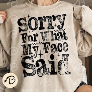 Pu&ograve; includere: Felpa beige con la scritta nera e audace "Sorry For What My Face Said". Il design include stelle e motivi a scacchi. Il logo del marchio &egrave; visibile in basso a sinistra.