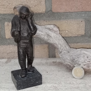 brązowa statuetka przedstawiająca „elektryka”