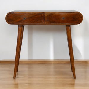 May include: A mid-century modern style wooden console table with two drawers. The table has a dark brown finish, rounded edges, and tapered legs. Each drawer has a small, round metal knob. The table is approximately 30 inches wide.