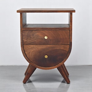 May include: A dark brown wooden nightstand with two drawers and a shelf. The nightstand has a curved front and four legs. The drawer pulls are round and gold.