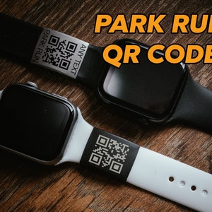 May include: Two smartwatches with black screens and bands. One watch has a black band, the other a white band. Each band has a QR code and the text "PARK RUN" and "ANY TEXT". The text "PARK RUN QR CODE" is in the background.