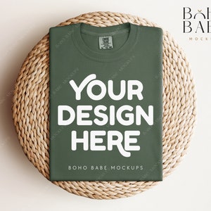 May include: A green t-shirt mockup with the text "YOUR DESIGN HERE" on a woven wicker surface. The text "BOHO BABE MOCKUPS" is printed on the bottom of the shirt.