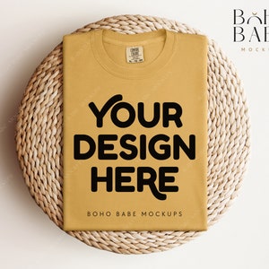 May include: A mustard yellow t-shirt with the text "YOUR DESIGN HERE" in black on a woven wicker background. The text "BOHO BABE MOCKUPS" is also visible on the t-shirt.