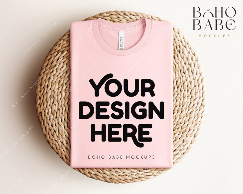 Może przedstawiać: Makieta r&oacute;żowej koszulki z nadrukiem "YOUR DESIGN HERE" na okrągłej plecionej macie. Na dole koszulki widnieje napis "BOHO BABE MOCKUPS".