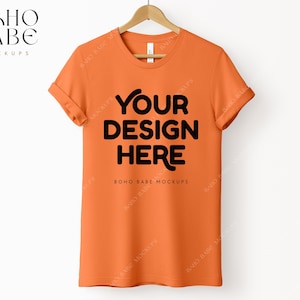 May include: Orange short-sleeved t-shirt mockup with the text "YOUR DESIGN HERE" and "BOHO BABE MOCKUPS" printed on the front.